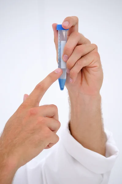 Две руки доктора, показывающие пересадку тестов в пробирке — стоковое фото