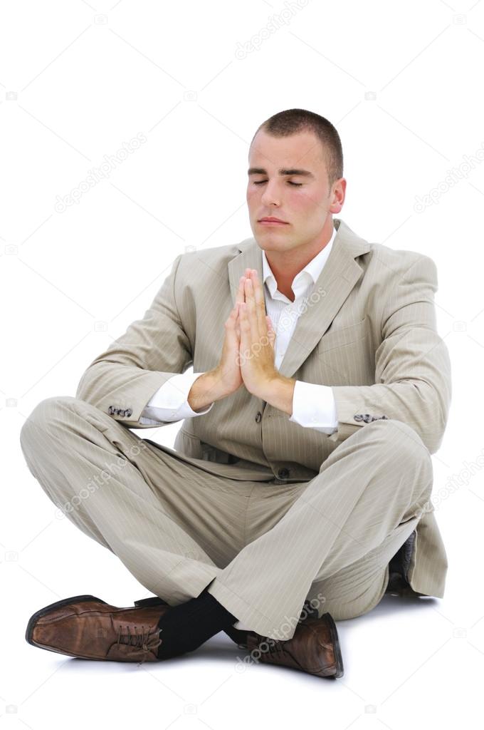 Young man meditating in office isolated on white