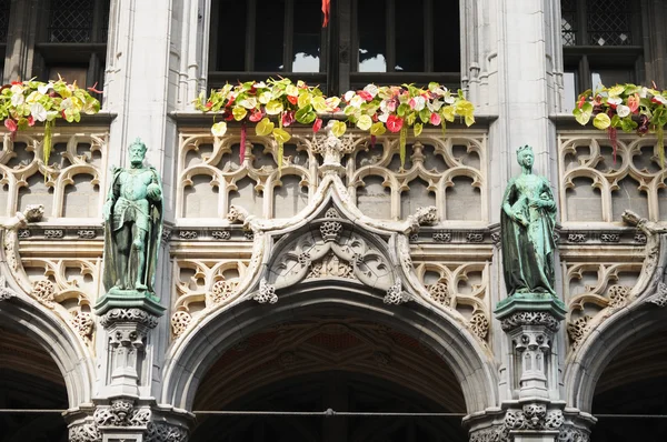 Details der neogotischen Eingangsfassade eines historischen Gebäudes auf einem großen Platz in Brüssel, Belgien bei sonnigem Tag mit Blumen — Stockfoto