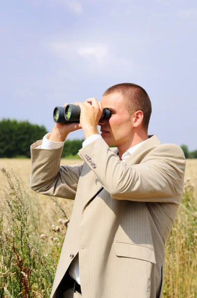 Agente de segurança observando através de binóculos no campo — Fotografia de Stock