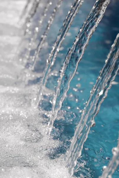 Agua limpia que fluye de muchos grifos con gotas brillantes — Foto de Stock