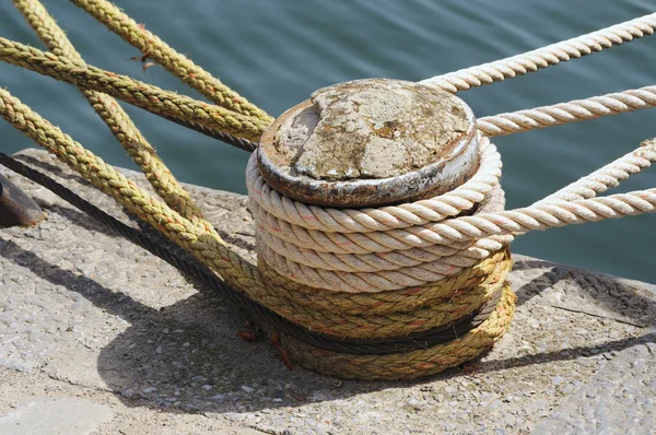 Bollard with ropes near water — Stock Photo, Image