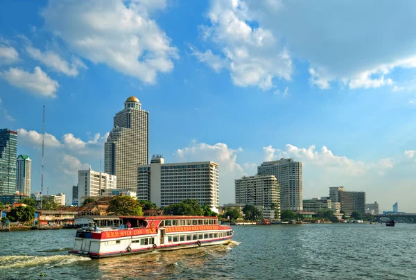 Turistické výletní lodi a moderní budovy na prosinec 22, 2009 v Bangkoku — Stock fotografie