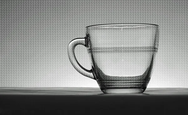 Transparente Vintage-Glas-Tasse hinterleuchtet in schwarz und weiß — Stockfoto