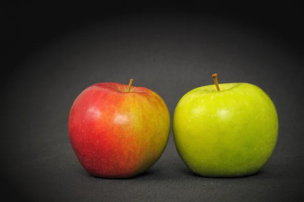 Červená a zelená jablka na tmavý stůl — Stock fotografie