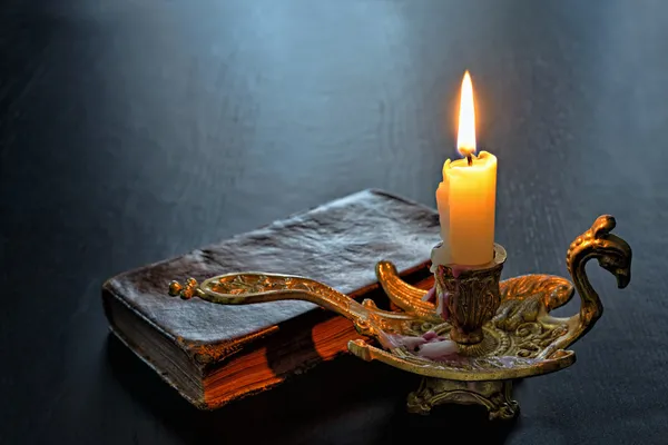 Antique book and firing candle — Stock Photo, Image