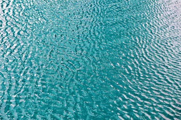 Água com pequenas ondas e reflexos de luz — Fotografia de Stock
