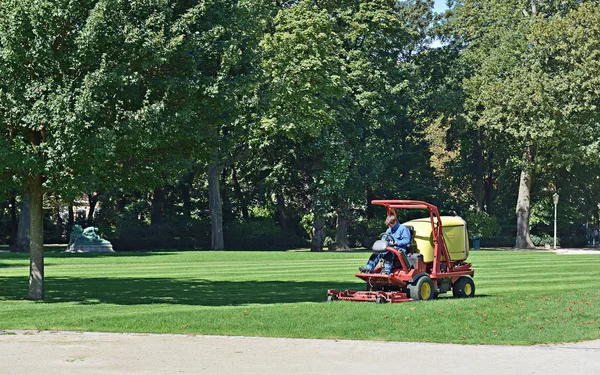 Unidentified worker cuts grass in Cinquantenaire Parc — Stock Photo, Image