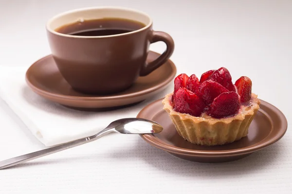 Tazza di tè su tovagliolo bianco con dessert alla fragola — Foto Stock