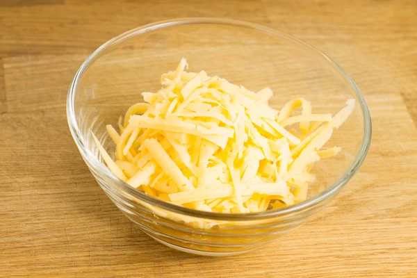 Grated Cheese on cutting board — Stock Photo, Image
