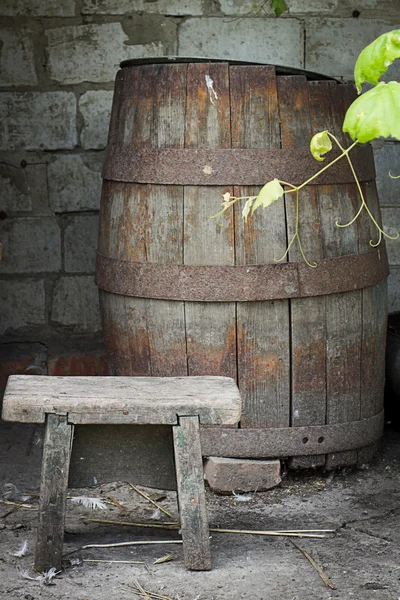 Venkovské Zátiší s starobylé stolice a barel a zelená vinná réva — Stock fotografie
