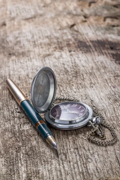 Antique watch and ink pen on wood weathered background — Stock Photo, Image