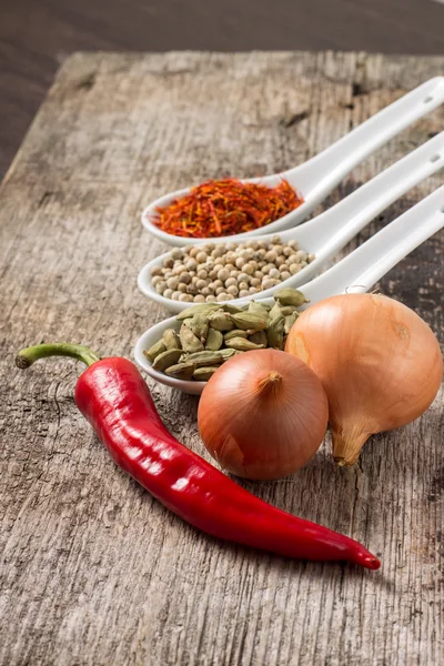 Fondo con especias y verduras en tablón de madera — Foto de Stock