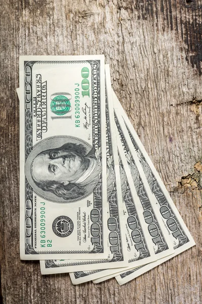 Hundreds of US dollars on old wooden plank — Stock Photo, Image