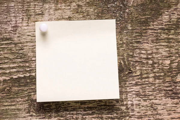 Adesivo de papel amarelo no fundo de madeira weathered — Fotografia de Stock