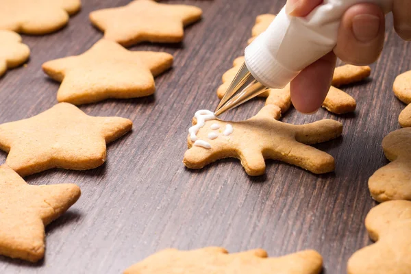 Decorating of gingerbread bears on wooden table — Stock Photo, Image