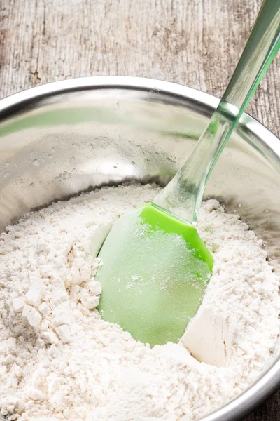 Mixing wheat flour in metallic bowl — Stock Photo, Image