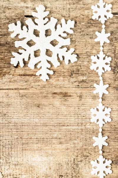 Kerstdecoratie. kunststof sneeuwvlokken op hout achtergrond — Stockfoto