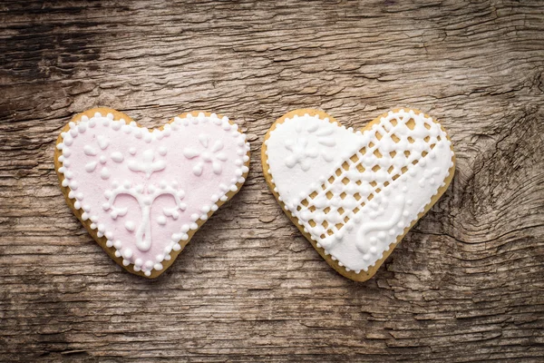 Two decorative heart cookies on textured wood background — Stock Photo, Image
