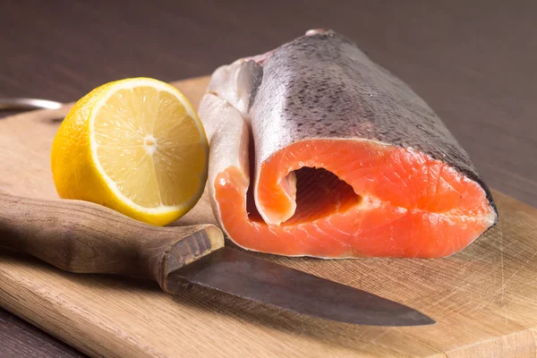 原料三文鱼配柠檬和切菜板上的刀 — 图库照片