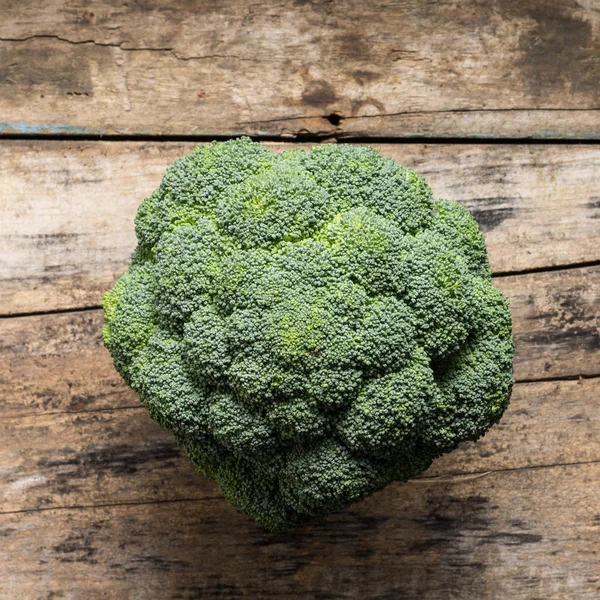 Broccoli over textured grunge wooden board — Stock Photo, Image