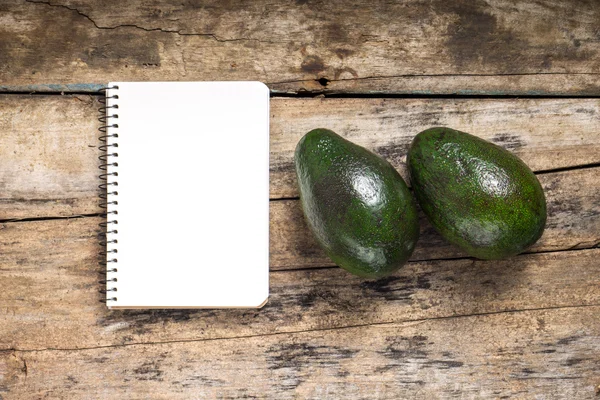 Recipe Notepad with two ripe avocado on wood background — Stock Photo, Image