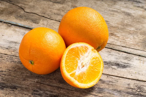 Whole and Cut in Half Orange lying on Textured Weathered Wooden — Stock Photo, Image