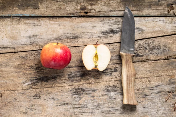 Whole and Cut in Half Apples with Knife lying on Textured Weathe — Stock Photo, Image