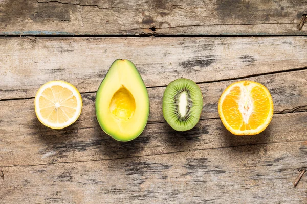 Various Fruits Cut in Half lying on Wodden Weathered Table — Stock Photo, Image