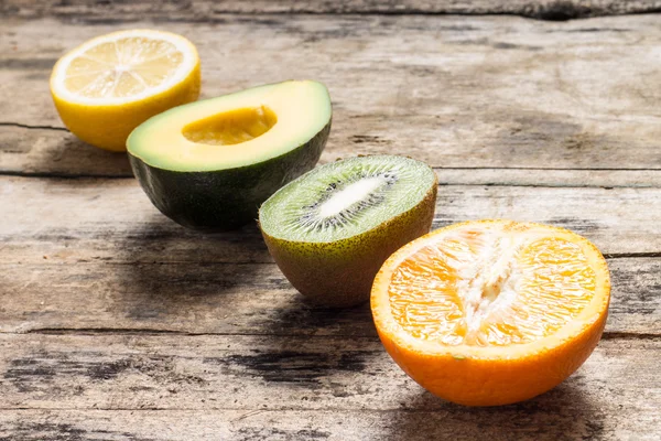 Various Fruits Cut in Half lying on Wodden Weathered Table — Stock Photo, Image