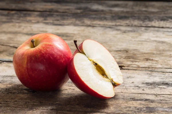 Σύνολο και κόψτε στο μισό μήλο, που βρίσκεται σε υφή διαβρωμένες ξύλινες — ストック写真