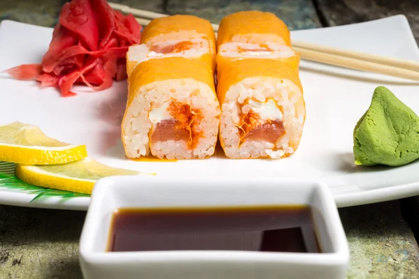 Traditional Philadelphia sushi rolls on white plate with chopstick and wasabi — Stock Photo, Image