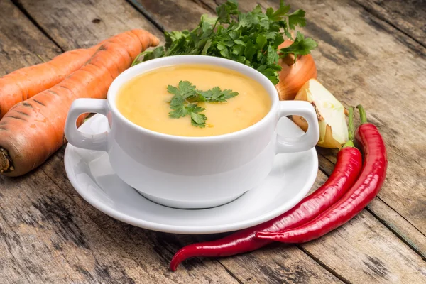 Organic food. Pea soup with vegetables around on wood background — Stock Photo, Image