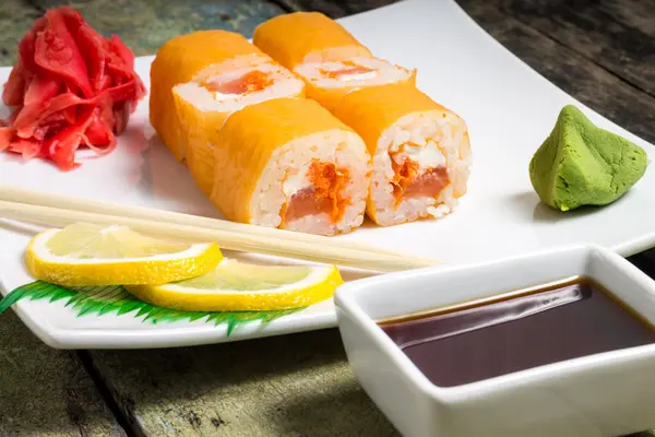 Traditional Philadelphia sushi rolls on white plate with chopstick and wasabi — Stock Photo, Image