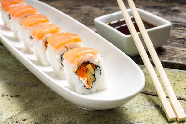 Rollos de sushi de mariscos en White Long Dish con salsa de soja — Foto de Stock