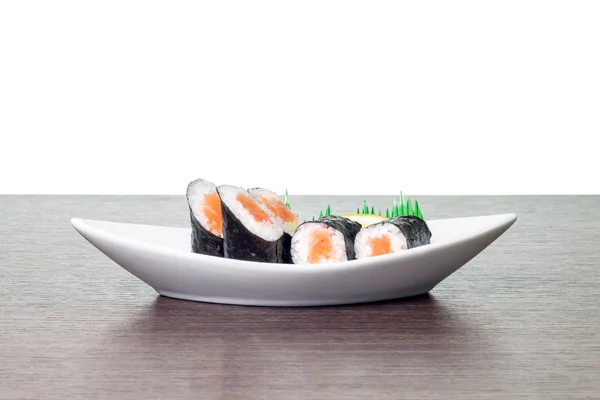 Sushi aux fruits de mer dans une assiette de bateau blanche. Maki sushi dans un plat avec copyspace — Photo