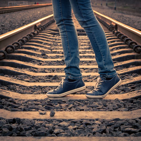 Una mujer caminando en el ferrocarril. Piernas femeninas en el camino —  Fotos de Stock