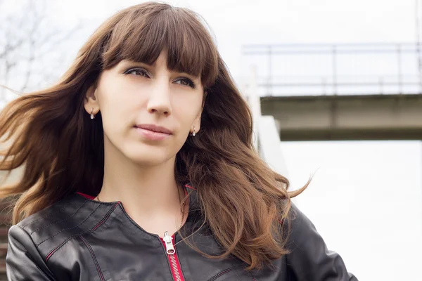 Young beautiful woman standing near railway station looking straight ahead — Stock Photo, Image