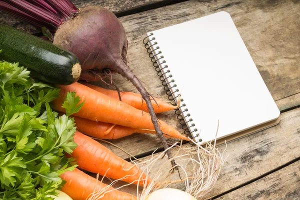 Recipe background. Fresh vegetables with blank page of cookbook — Stock Photo, Image