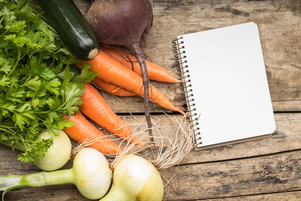 Recipe background. Fresh vegetables with blank page of cookbook — Stock Photo, Image