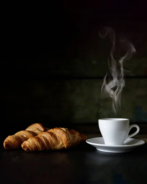 Cup of espresso with two fresh croissants against dark background — Stock Photo, Image