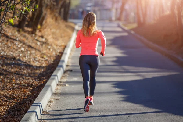 Rear view of young running woman on the road in cold winter morning — Stock Photo, Image