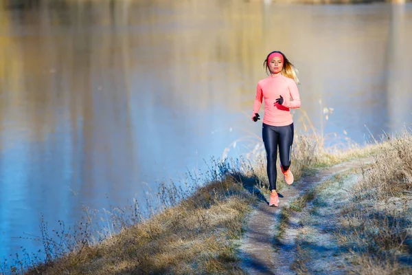 Fitness lány kocog a parkban közel tó a fagyos reggel. — Stock Fotó