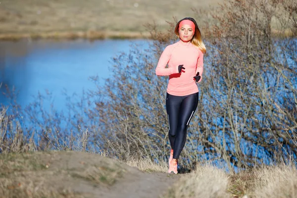 Jeune femme de fitness courant le matin par temps froid et ensoleillé — Photo