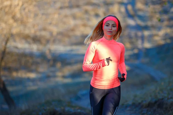 Közelkép fiatal futó nőről a parkban a fagyos reggelen — Stock Fotó