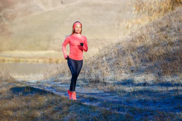 Jovem mulher fitness correndo no parque no início da manhã gelada — Fotografia de Stock