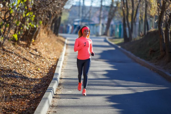 Young fitness girl jogging on the road in the frosty morning — Stock Photo, Image