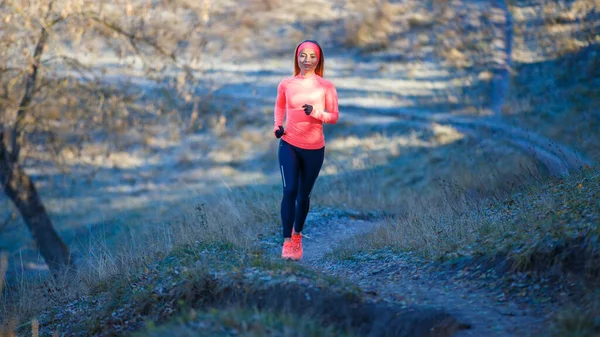 Jovem mulher fitness correndo no parque no início da manhã gelada — Fotografia de Stock