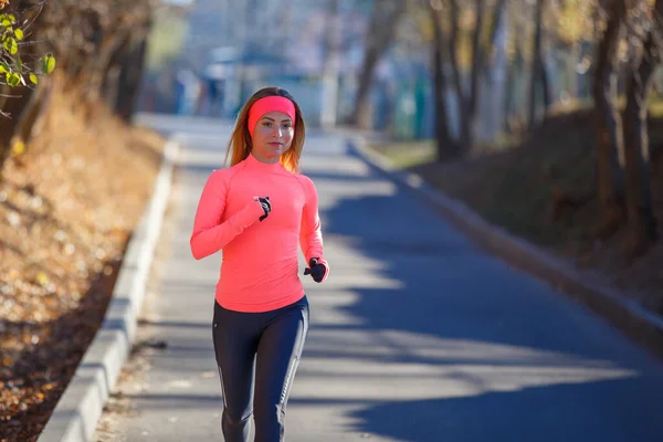 Молодая спортивная девушка бегает по дороге в морозное утро — стоковое фото