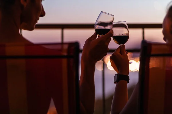 Silhouette of couple drinking wine at the sea view terrace in the evening. Valentine day image